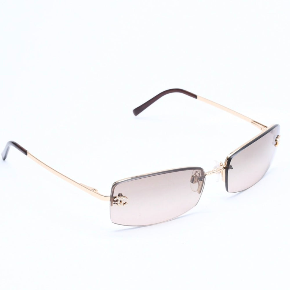 Mint condition CHANEL rimless glasses with side Coco mark, brown lenses, rhinestones, and gold hardware, 4093-B, size 56.◻16 130 Used 4a010062