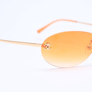 CHANEL rimless sunglasses with side Coco mark, orange lenses, and gold hardware, model number 4013 c.125/56, size 59.◻16 130 Excellent condition Used 4a010063