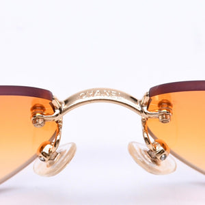 CHANEL rimless sunglasses with side Coco mark, orange lenses, and gold hardware, model number 4013 c.125/56, size 59.◻16 130 Excellent condition Used 4a010063