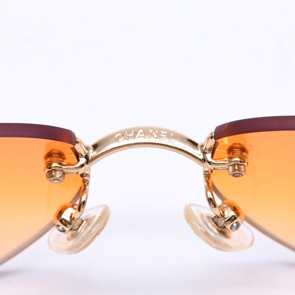CHANEL rimless sunglasses with side Coco mark, orange lenses, and gold hardware, model number 4013 c.125/56, size 59.◻16 130 Excellent condition Used 4a010063